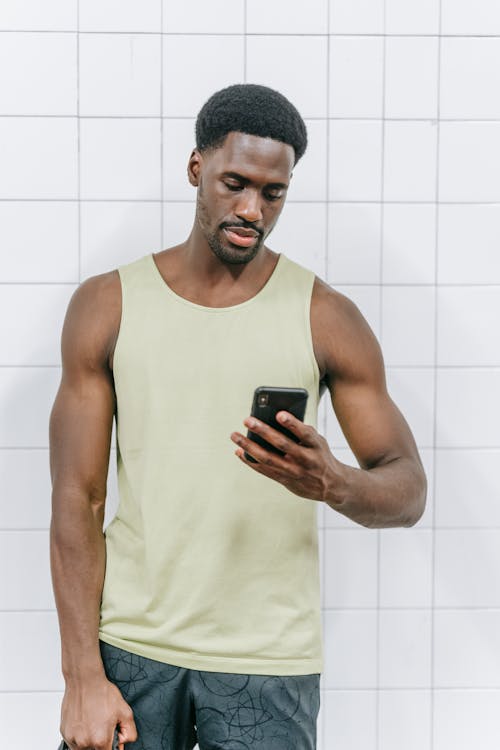 Free Man in Tank Top Holding a Cellphone Stock Photo