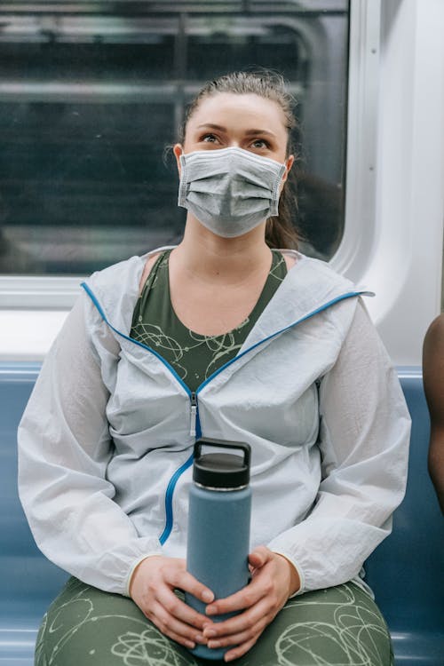A Woman Wearing Face Mask Sitting in the Train