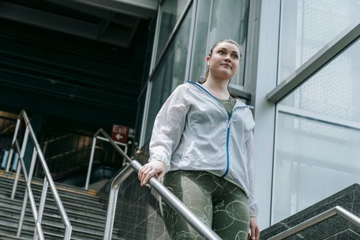 Active woman in sportswear walking down stairs, capturing a moment of motivation.