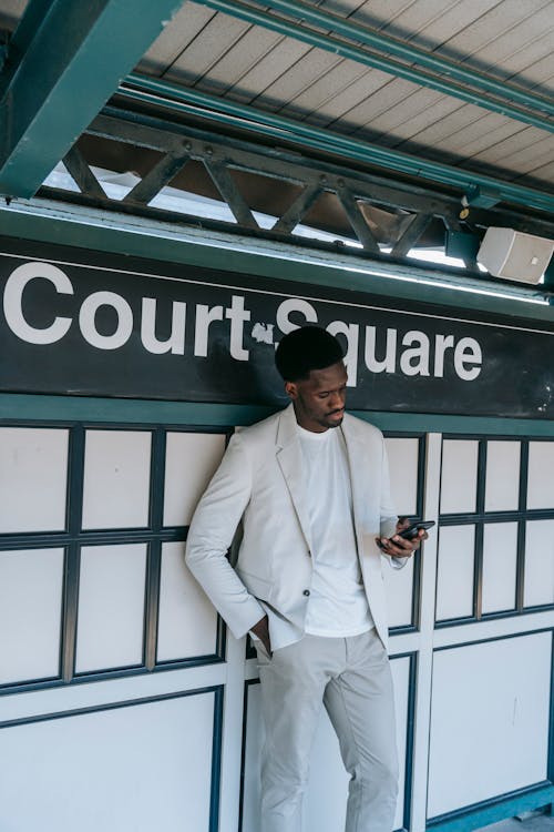 Man Standing on a Subway Station and Using Phone 