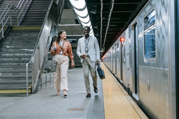 A Man And Woman Walking In The Train Station