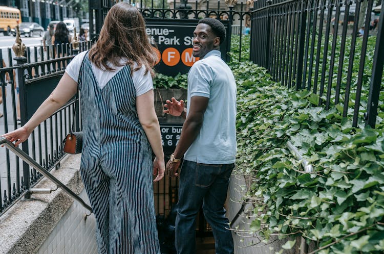 Man And Woman Doing Down The Stairs To A Subway Station 