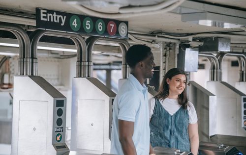 Free A happy couple entering a subway station, smiling and enjoying their commute. Stock Photo