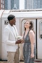 微笑的跨种族夫妇手持鲜花，站在火车旁