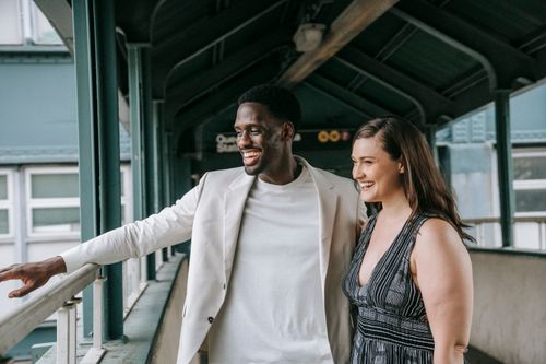 Free Smiling couple walking together in an urban environment, enjoying a bright day. Stock Photo