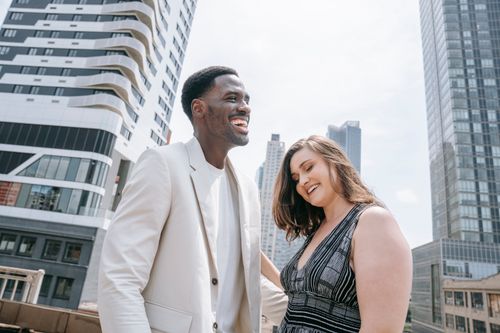 Free Smiling couple standing together in the city, enjoying a sunny day. Stock Photo