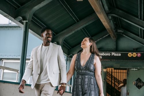 Free A happy couple holding hands at Queensboro Plaza subway station, expressing love and connection. Stock Photo