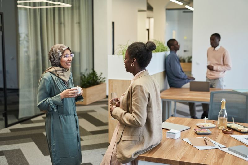 Diverse group of professionals interacting in a modern office setting.