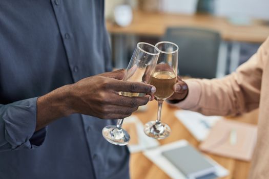 Two people celebrating with a champagne toast in an indoor setting.