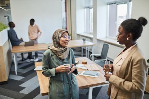 Free Group of professionals conversing in a modern office. Diverse and engaging. Stock Photo