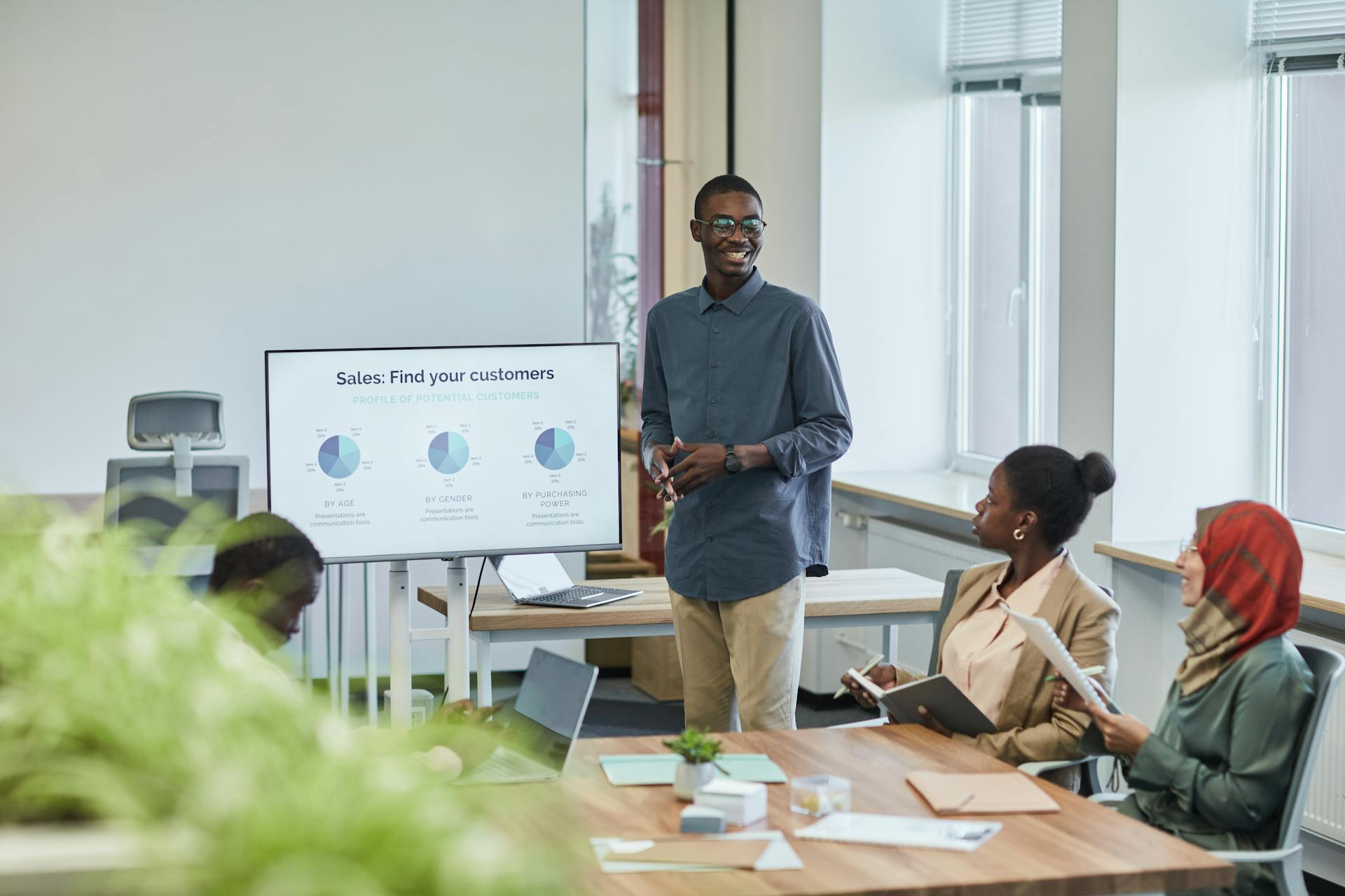 A diverse team having a corporate meeting with a sales presentation in a modern office setting.