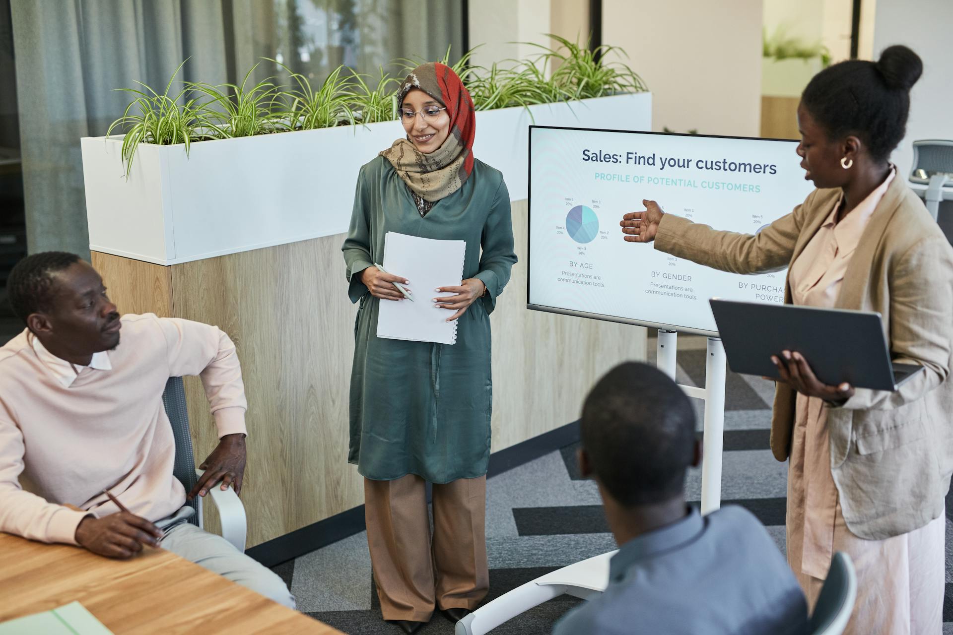 Team of professionals discussing sales strategy during a business presentation in a modern office.