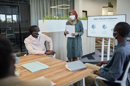 Free Team meeting with masks and a presentation on customer sales analysis. Stock Photo