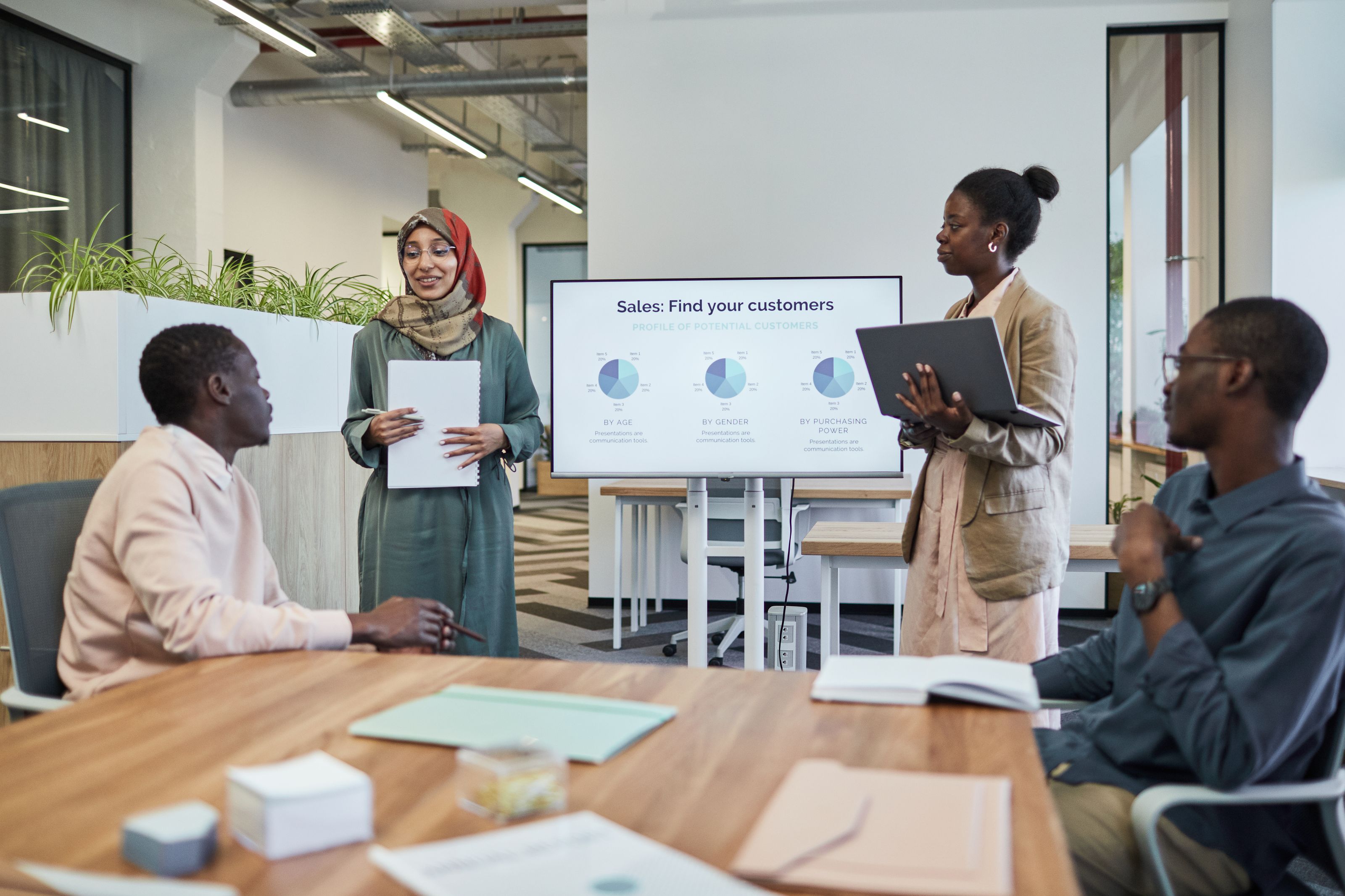 A diverse team discusses business strategy during an indoor presentation.
