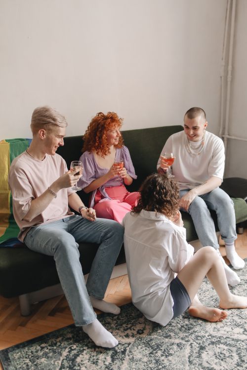 Free A group of friends enjoying a relaxed indoor gathering, sharing drinks. Stock Photo