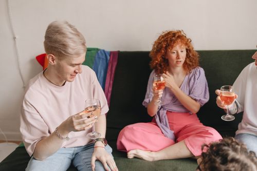 Free A cozy indoor gathering with friends enjoying conversation and wine. Stock Photo