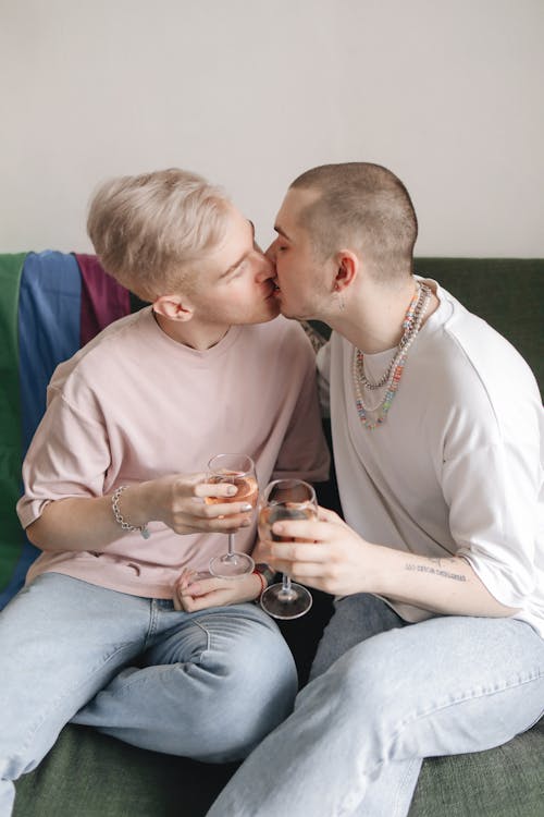 Free Two Men Kissing While Sitting on a Couch  and Having Drinks Stock Photo