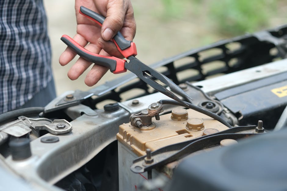 of a technician testing a car battery in a customer's driveway - mobile battery service of a technician testing a car battery in a customer's driveway - mobile battery service