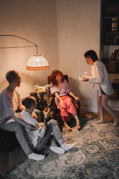 Friends gather indoors for a cozy birthday celebration with cake.
