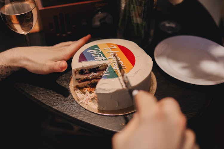 A Person Slicing The Cake