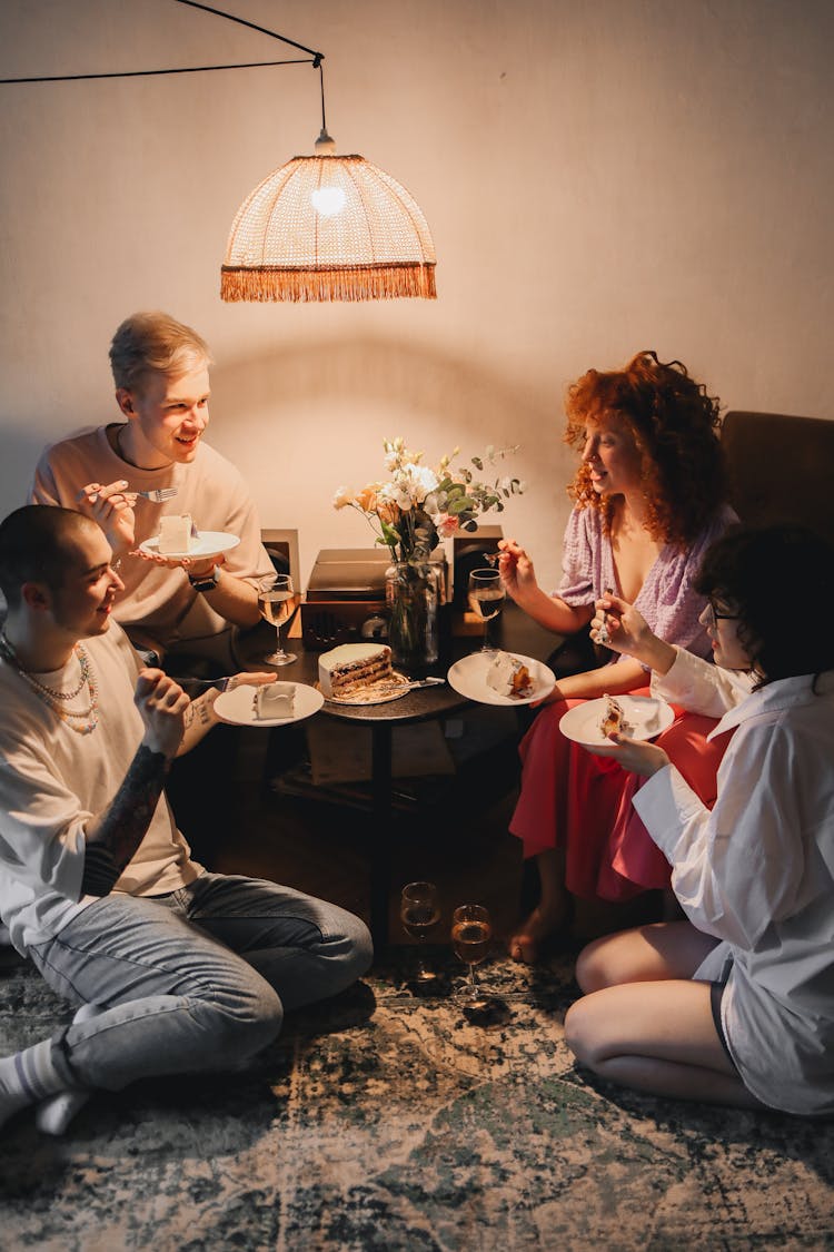 A Group Of Friends Eating Cake While Having Conversation