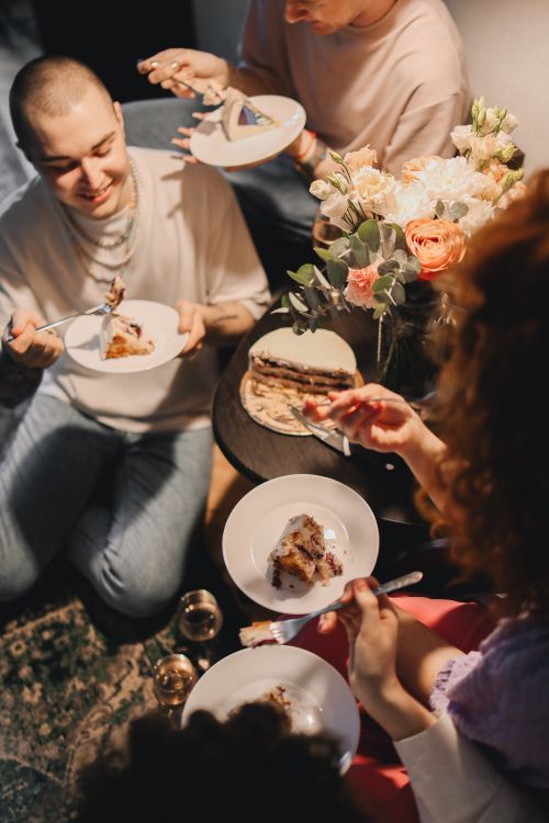 Free A group of friends enjoying cake and conversation at a cozy indoor birthday celebration. Stock Photo