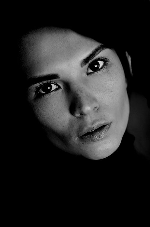 Free Close-up black and white portrait of a woman with a dramatic expression and lighting. Stock Photo