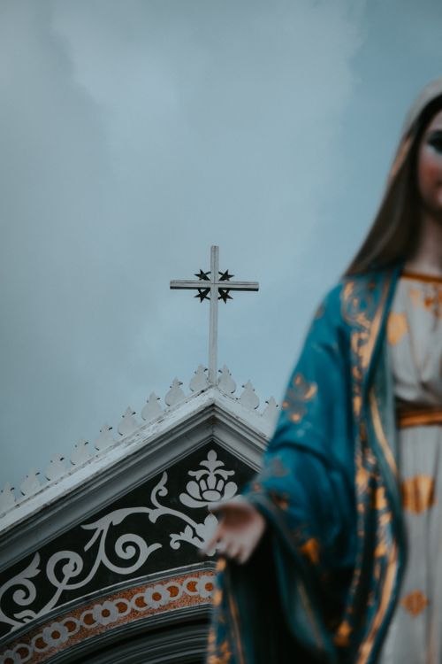 Free Close-up of a Gothic church's architectural details with Virgin Mary statue in foreground. Stock Photo