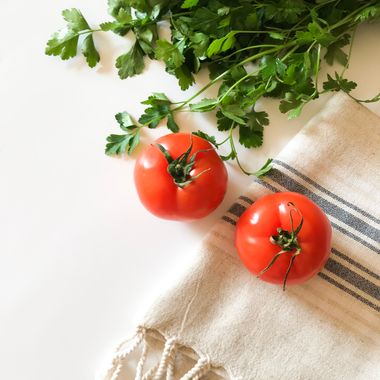 Fresh tomatoes and parsley on a woven cloth — photo by pelin erdogan on Pexels