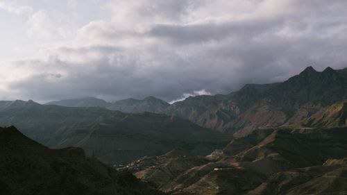 Free Serene mountain landscape with overcast sky and village nestled in the valley. Stock Photo