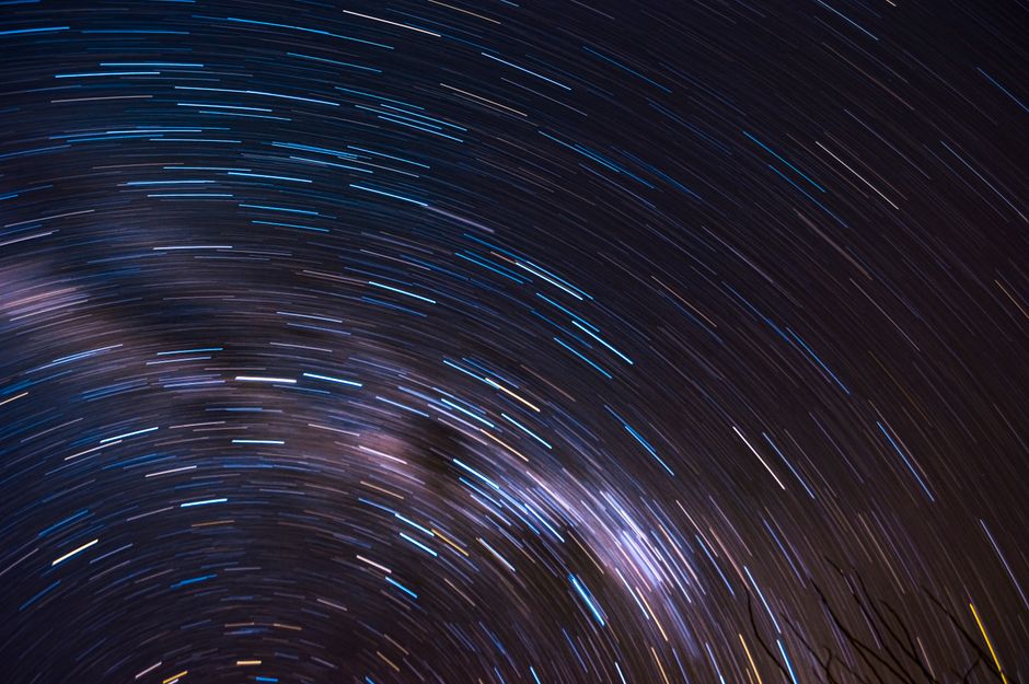 Vivid star trails creating circular patterns against a clear night sky.