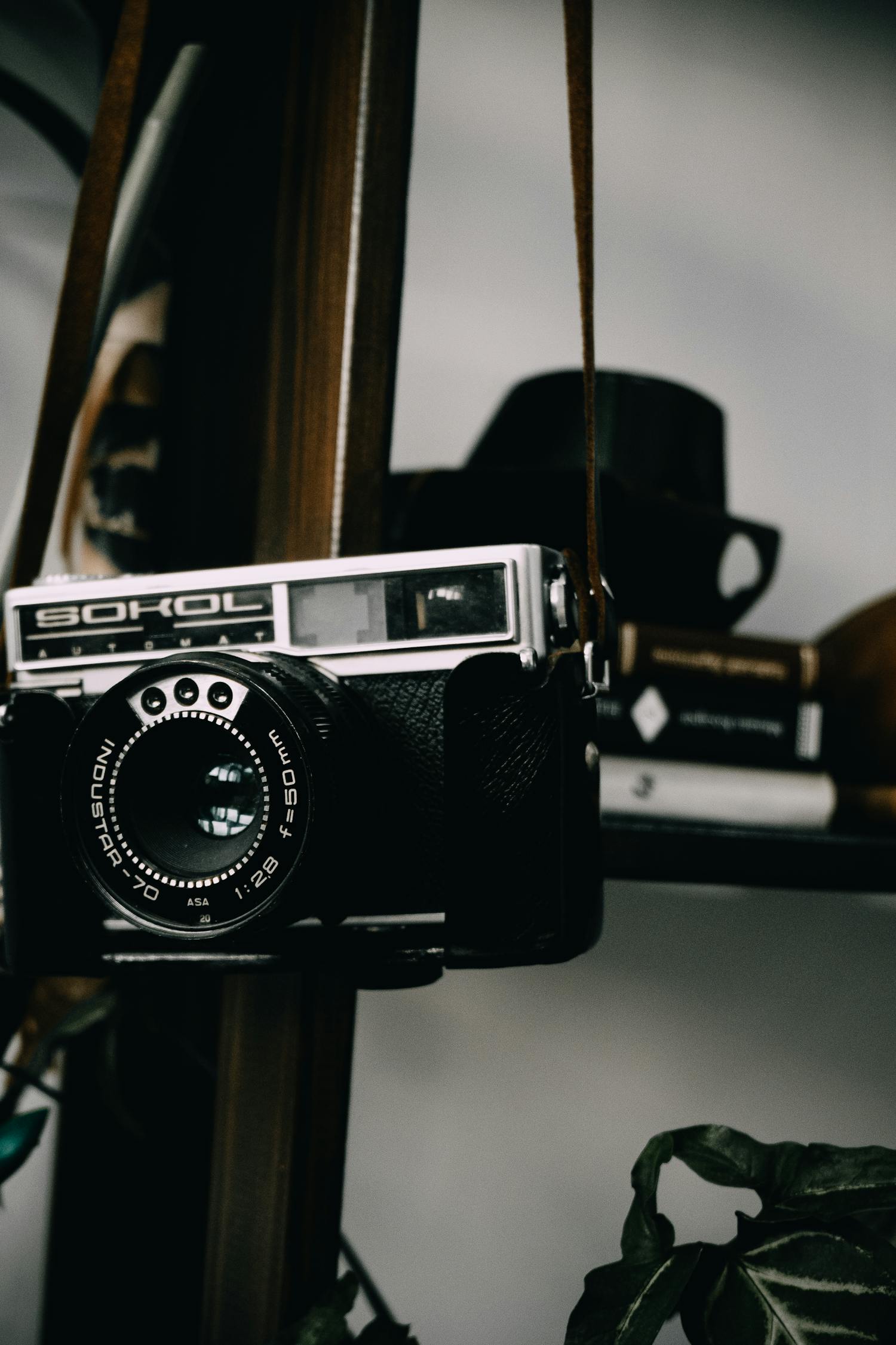 Black and Silver Camera on Brown Wooden Rack