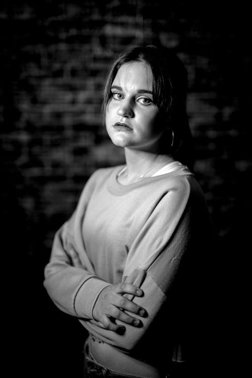 Grayscale Photo of a Woman with Her Arms Crossed