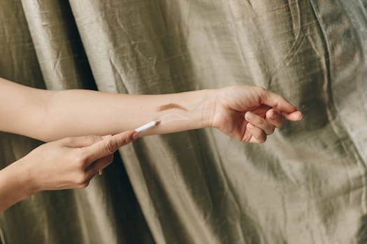 Close-up view of a woman's arm with makeup swatches on a subtle background. Ideal for beauty and cosmetics content.