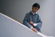 Man in Blue Dress Shirt Sitting on White Bench