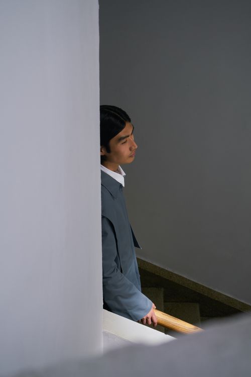 Free A man in a gray suit holds a handrail while thoughtfully descending stairs. Stock Photo
