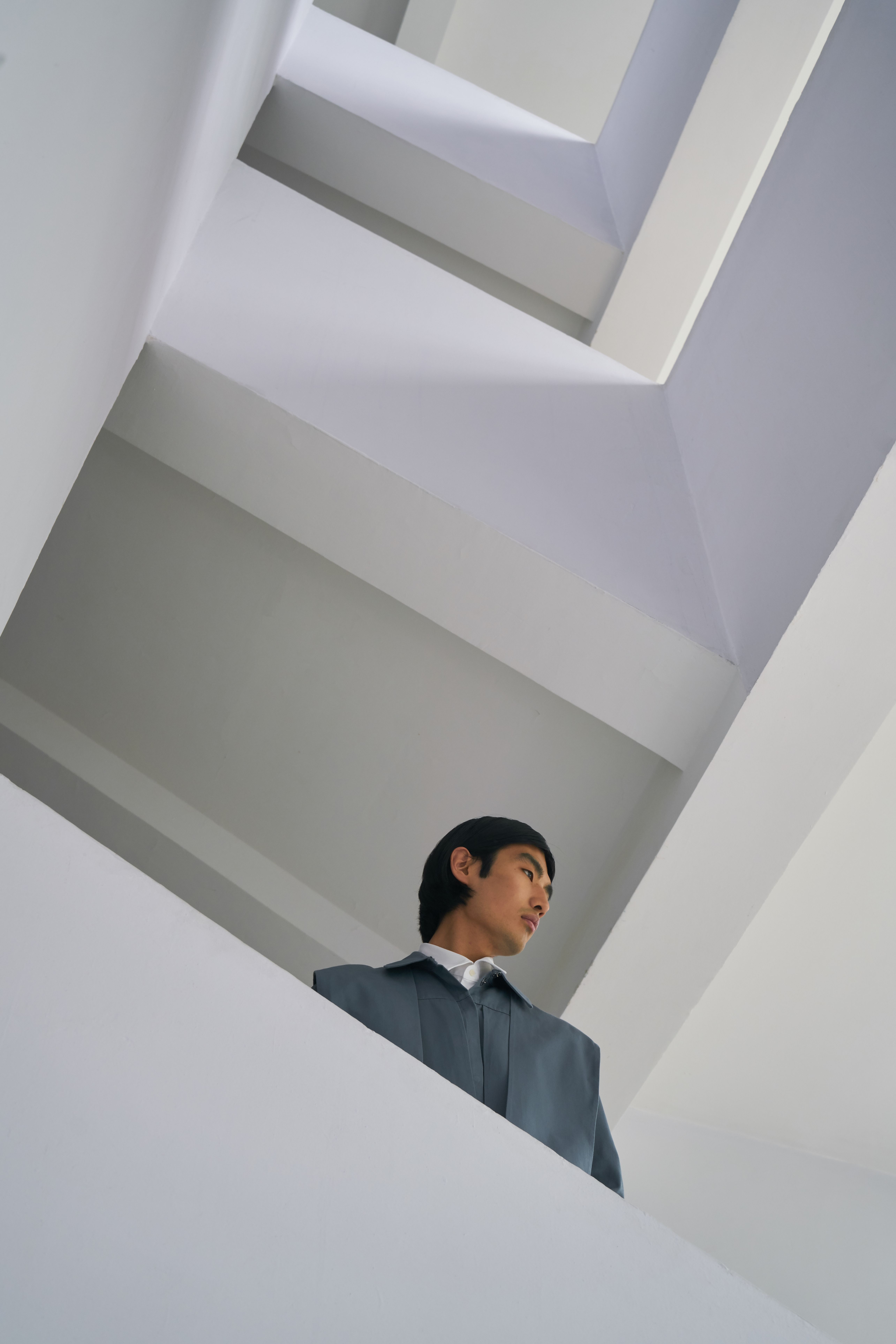 Low angle shot of a man in a geometric architectural space.