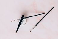 Tweezer, Make-up Brushes and Brow Soap on a Pink Surface