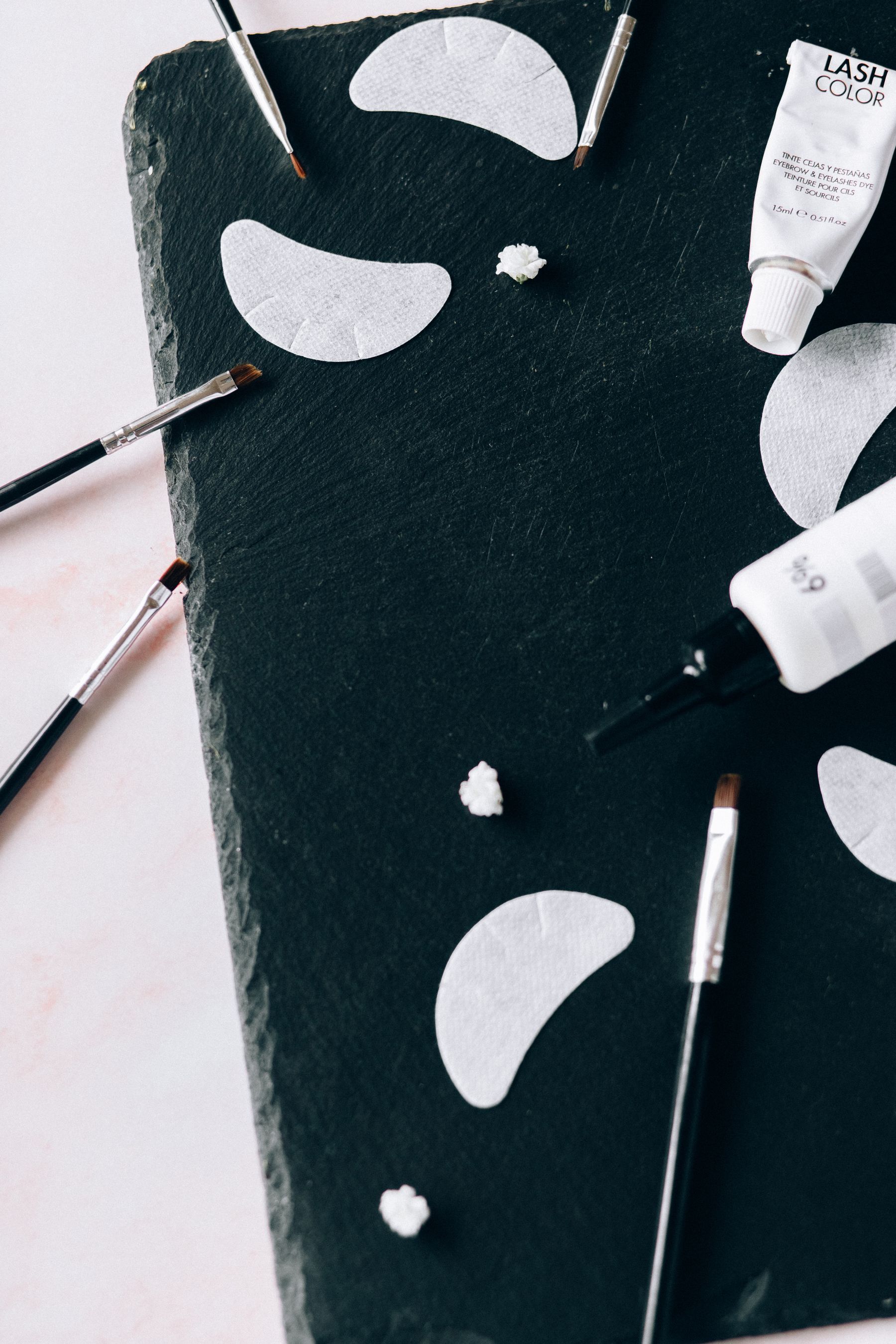 Makeup brushes and cosmetic tools arranged in an elegant editorial flat lay