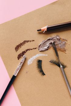 Artistic flat lay of makeup products on a brown and pink background.. artistic, flat, makeup