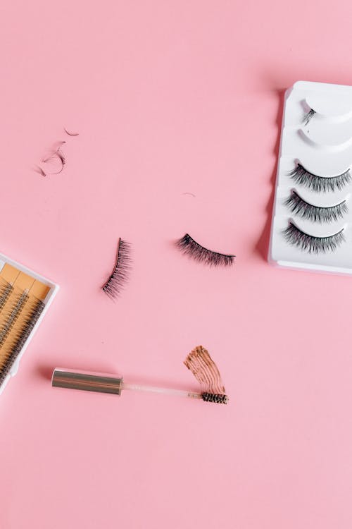 Eyelashes and Mascara Brush on a Pink Surface