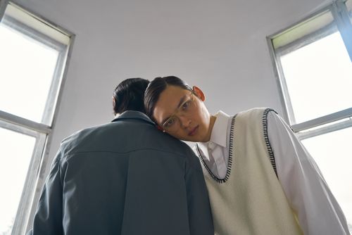 Free Intriguing portrait featuring two men in a minimalist room, highlighting emotion and fashion. Stock Photo