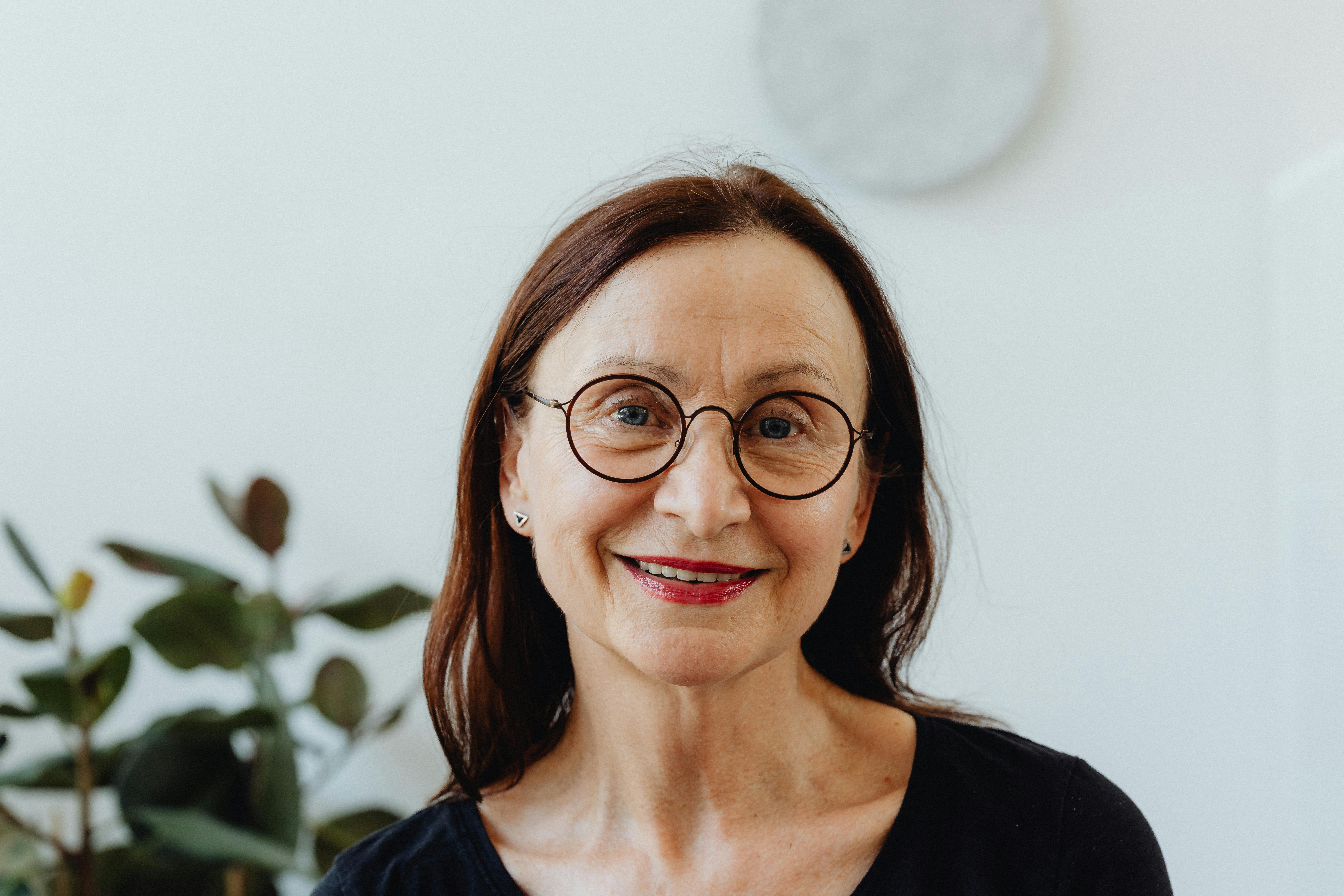 an elderly woman smiling while wearing eyeglasses