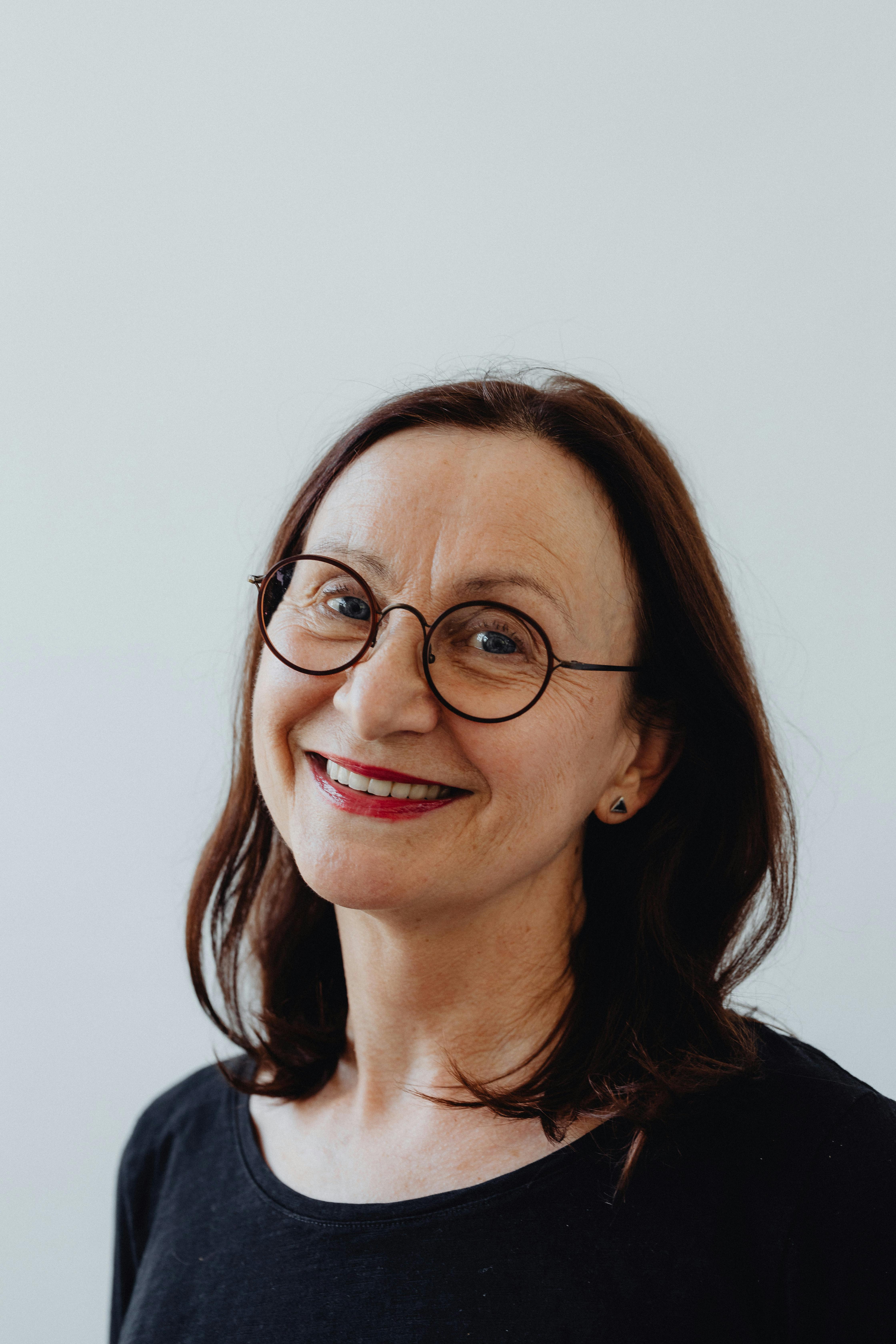 an elderly woman wearing eyeglasses while smiling