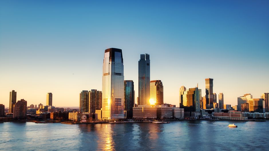 Fotomural Impresionante vista del amanecer sobre el horizonte de Nueva York con reflejo en el agua.
