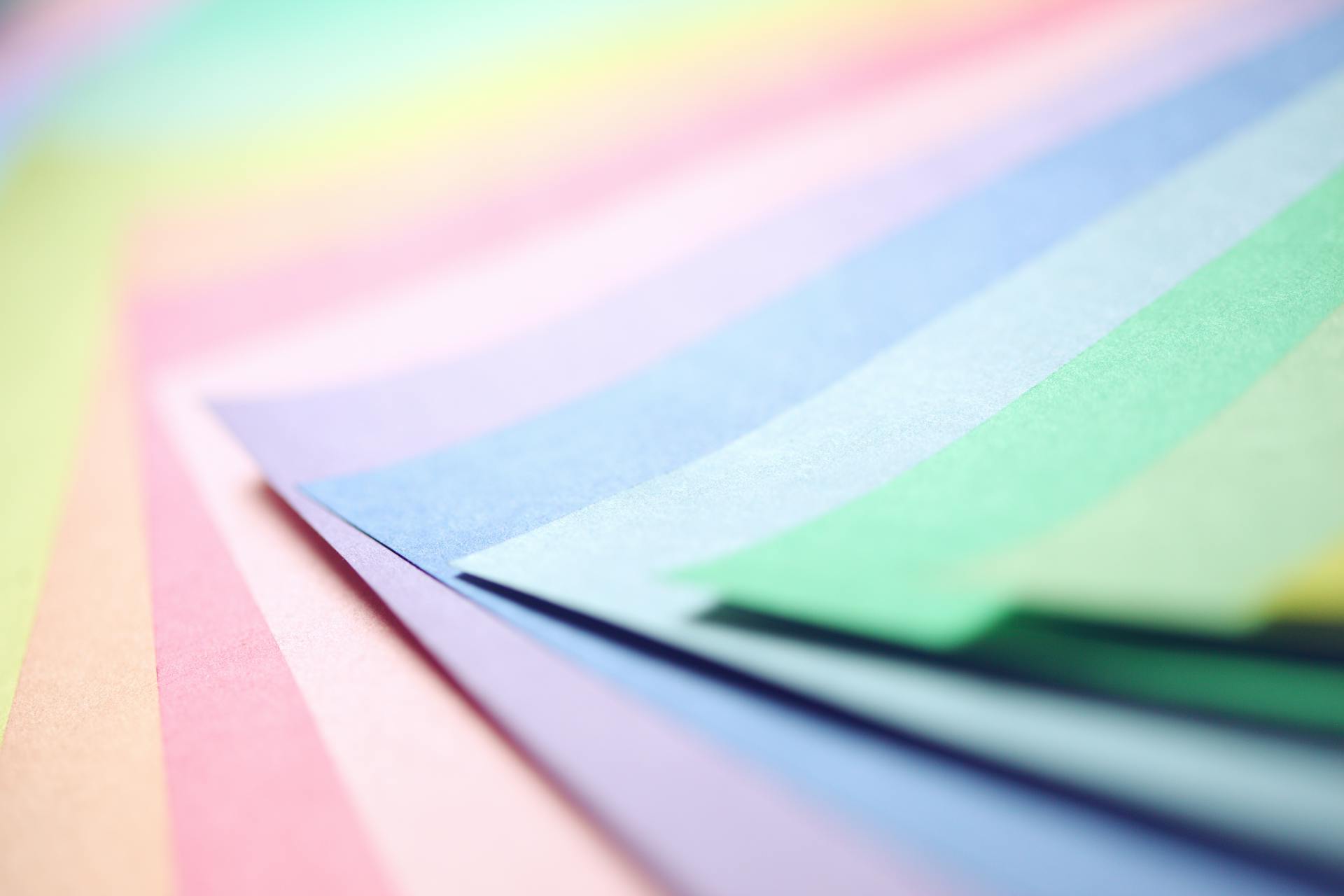 Vivid display of layered colorful pastel papers arranged in a gradient pattern.