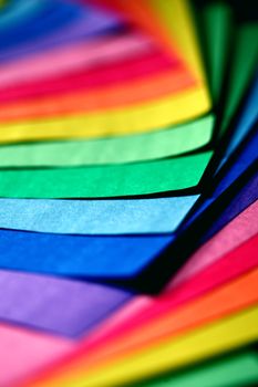 A colorful arrangement of paper sheets showcasing a rainbow spectrum in a close-up view.