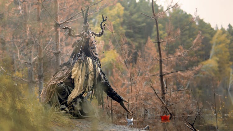 A Creepy Creature Sitting Near Leafless Trees