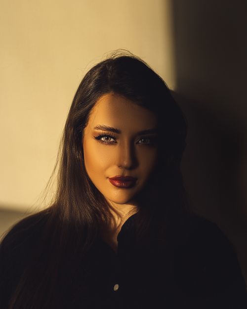 Free A striking portrait of a woman with red lips cast in dramatic shadows, creating a captivating and moody atmosphere. Stock Photo