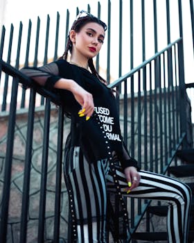 Fashionable woman stands confidently on stairs, showcasing modern style.